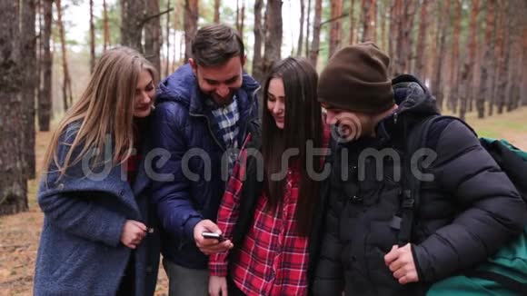 森林里一群游客的特写通过看电话讨论他们的路视频的预览图