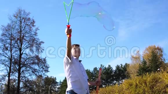 公园里的一个年轻人制造大肥皂泡假日和户外娱乐视频的预览图