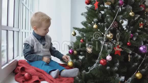 小男孩装饰圣诞树玩具假期礼物和新年概念视频的预览图