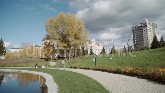 一个穿灰色运动服的女孩沿着池塘周围的人行道跑慢动作视频的预览图