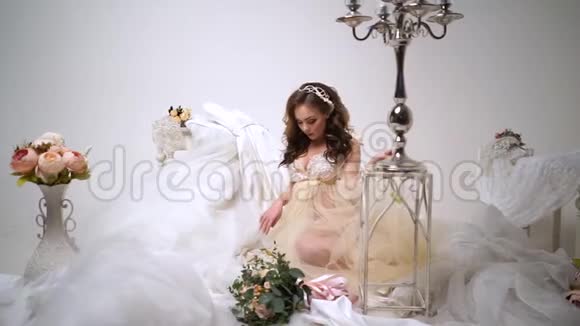 美丽的新娘被婚纱包围围绕着花束和装饰他身上穿着紧身衣视频的预览图
