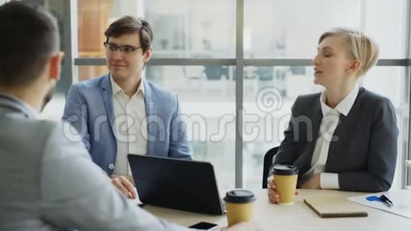 商务团队在咖啡休息期间坐在现代办公室室内聊天视频的预览图
