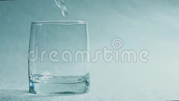 水倒在白色背景上的玻璃杯里视频的预览图