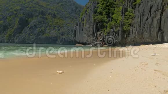 菲律宾巴拉望海景和美丽的海滩沙滩上的岩石阳光明媚的日子里有蓝色的海浪视频的预览图