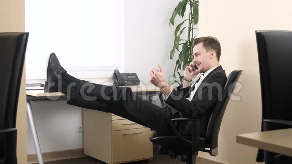 年轻人坐在办公室用手机说话挤压手扩张器60英尺视频的预览图