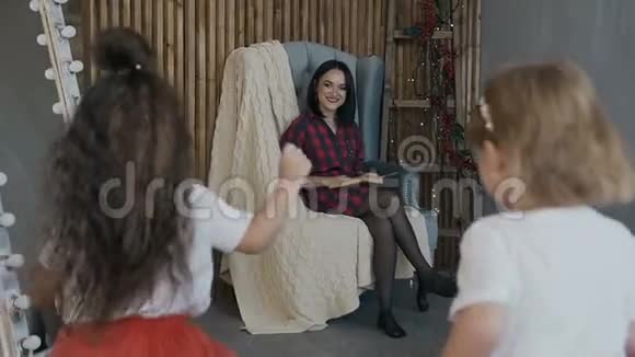 快乐的孩子黑发和金发和他们迷人的母亲在平安夜玩得开心一个幸福的家庭视频的预览图