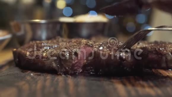 在木板上用刀子切下的热美味牛排行动中熟度牛排视频的预览图