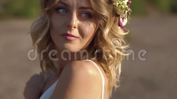 这位美丽的姑娘在山上度假时穿着白裙和鲜花的画像视频的预览图