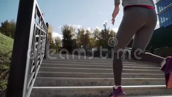 女孩跑上楼梯跑步者跑上楼梯慢动作摄像机升起了视频的预览图