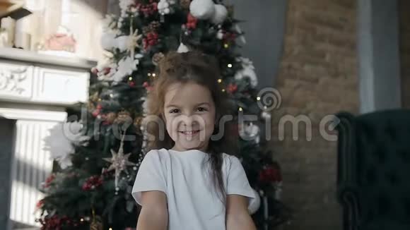 小女孩站在圣诞树旁手里拿着圣诞礼物视频的预览图