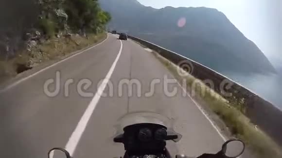 在黑山山区的乡村公路上开车旅行冒险用行动相机拍摄骑摩托车视频的预览图