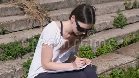 坐在公园里做作业的小女孩大学生视频的预览图
