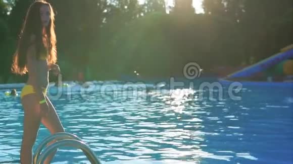 穿着泳衣的年轻女孩潜入游泳池留下一滴水视频的预览图