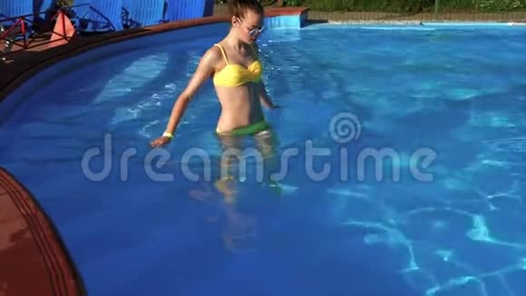 一个身材好的成年女孩进入室外游泳池的水中视频的预览图