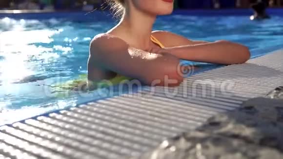 夏天一个有魅力的女人在游泳池里享受水处理视频的预览图