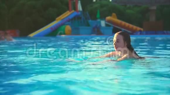 可爱的小女孩潜入游泳池在炎热的天气里凉快一下视频的预览图