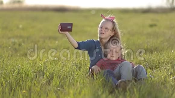 微笑的兄弟姐妹在草地上自拍视频的预览图