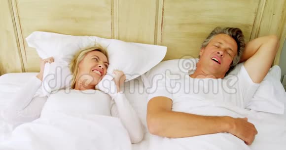 男人在床上打鼾时女人很生气视频的预览图