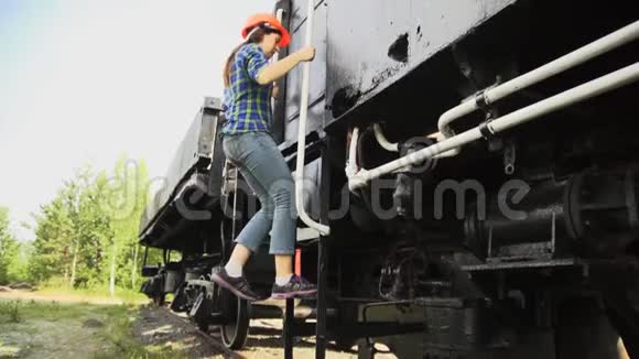 一个年轻的女火车司机走下楼梯走到火车旁边视频的预览图