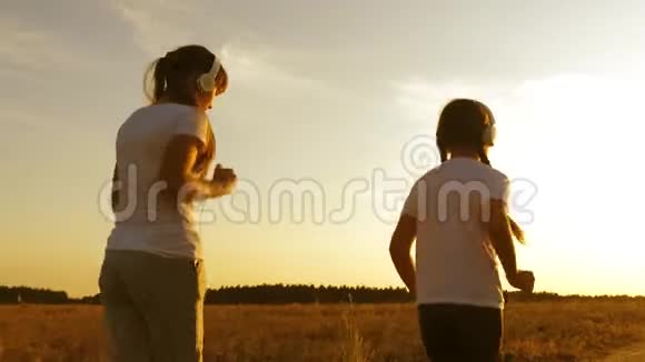 十几岁的女孩戴着耳机在农村慢跑年轻女孩正在日落时分训练和倾听视频的预览图