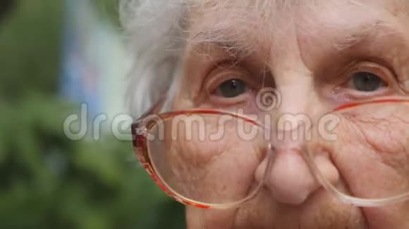 戴眼镜的老妇人转过头看着摄像机奶奶在外面戴眼镜肖像视频的预览图
