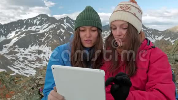 旅游女性自由职业者使用一台电脑在自然界并坐在草地旁边的煤气火炬山区反映在视频的预览图