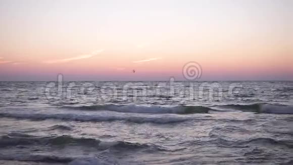 黎明时分一个穿着飘舞衣服的年轻女孩在海上码头漫步迎着冉冉升起的海面孤独的剪影视频的预览图