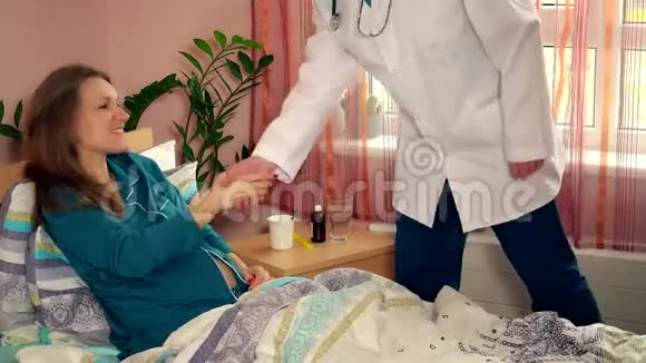 礼貌的医生男人和孕妇病人握手视频的预览图