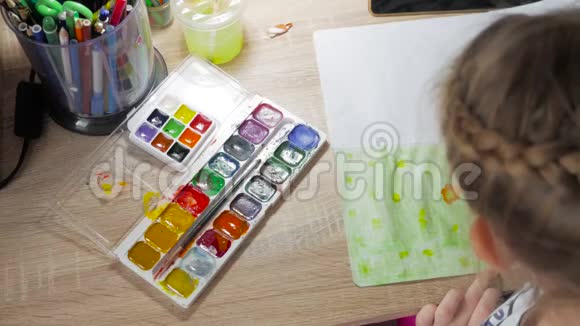 十几岁的女孩在家里从事创意在房间的一张桌子上画水彩幼儿绘制俯视图艺术作品视频的预览图