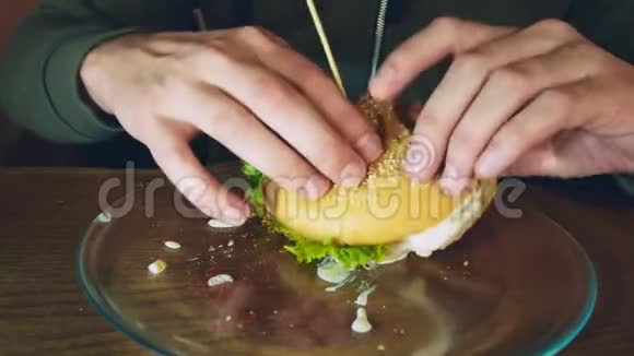 特写镜头一个男人在吃汉堡吃美味汉堡的过程视频的预览图