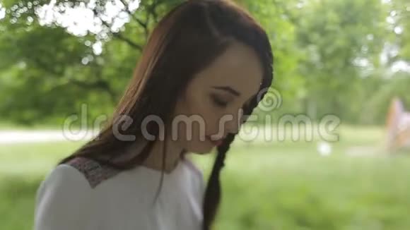 一幅身着乌克兰刺绣礼服的年轻迷人的黑发女郎在公园散步的肖像视频的预览图