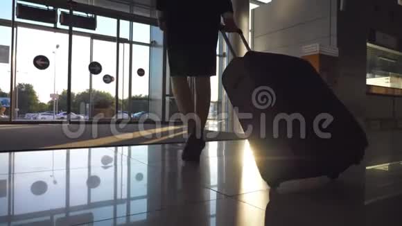 商务小姐带着行李从机场出发穿高跟鞋的女人带着她的手提箱从终点站走到城市街道视频的预览图
