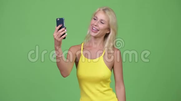 年轻快乐的金发美女视频通话显示电话视频的预览图