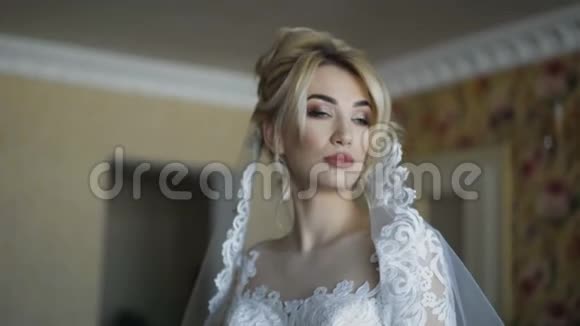 华丽的新娘微笑着在室内镜头前轻松摆姿势视频的预览图