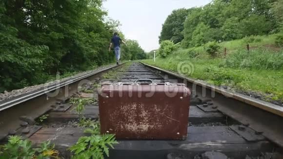 铁路线路上的旧手提箱视频的预览图