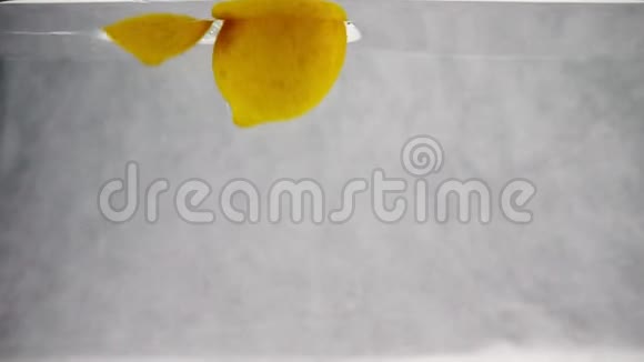 黄色柠檬被扔进一个容器里慢动作录像视频的预览图