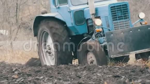 蓝色拖拉机与四沟犁犁田与黑土近景视频的预览图