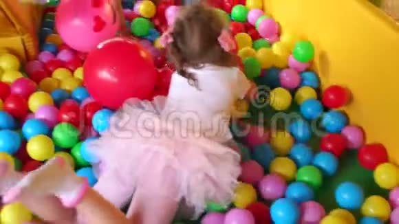 小女孩用塑料球在游泳池里爬行视频的预览图