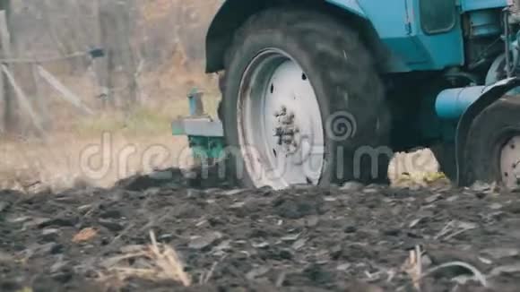 蓝色拖拉机与四沟犁犁田与黑土近景视频的预览图