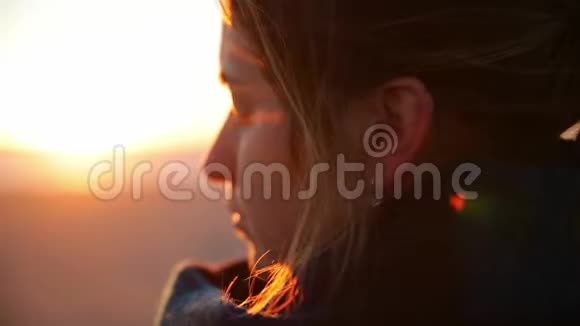 年轻女子在黎明或日落时在岩石上靠近海洋练习瑜伽冥想把她关起来视频的预览图