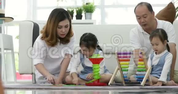 快乐的亚洲家庭和两个女儿在家玩耍视频的预览图