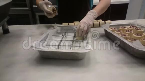 面包师把美味的卷饼放在托盘上烤在烤箱里糖果里视频的预览图