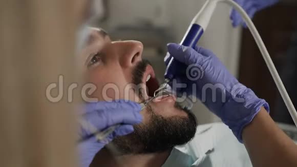 一位女牙医和她的助手给她的病人治牙视频的预览图