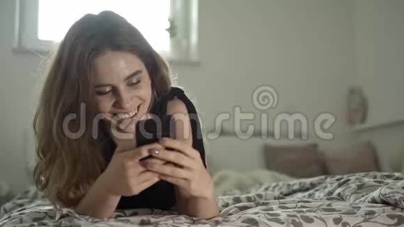 年轻的黑发和她的智能手机视频的预览图