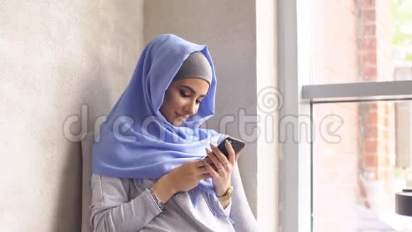 戴头巾的女孩用手机发信息视频的预览图