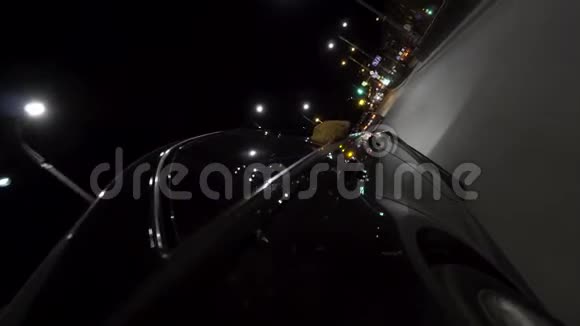 快速黑色汽车在夜间行驶穿过城市从车轮上观看录像现代车辆沿着繁忙的道路行驶视频的预览图