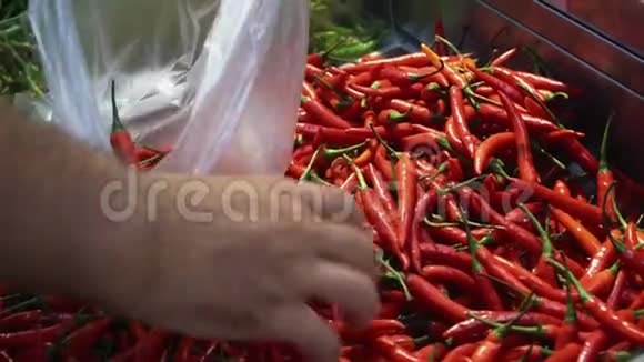 男性顾客购物时将辣椒放入食品超市的塑料袋中视频的预览图