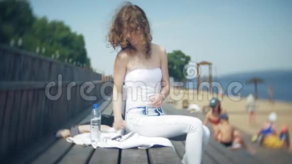 热辣的女孩躺在沙滩上晒太阳视频的预览图