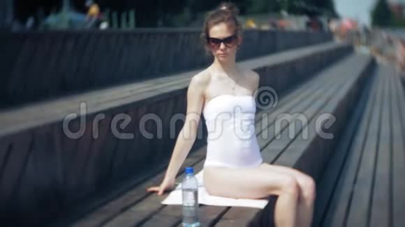 热辣的女孩躺在沙滩上晒太阳视频的预览图