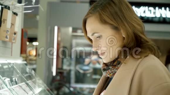 一个家电店的女人用照相机看着商店的橱窗视频的预览图